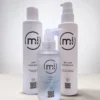 Trzy wegańskie kosmetyki marki Mi and I: wzmacniający tonik do skóry głowy Scalp Tonic, delikatny szampon Soft Shampoo oraz nawilżająca odżywka Rinse Conditioner.