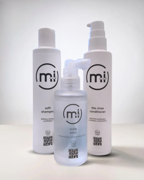 Trzy wegańskie kosmetyki marki Mi and I: wzmacniający tonik do skóry głowy Scalp Tonic, delikatny szampon Soft Shampoo oraz nawilżająca odżywka Rinse Conditioner.
